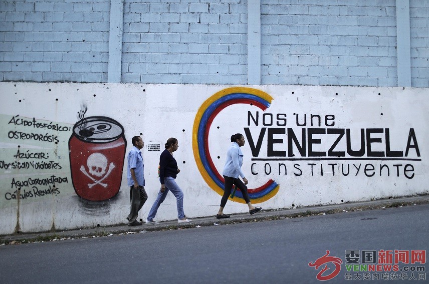 gente-camina-frente-a-un-anuncio-de-constotuyente-en-venezuela-reuters.jpg